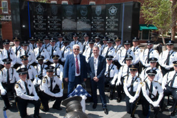 Lazar Finker and Eugene Frenkel stand with police officers in front of a police memorial wall in Jacksonville, Florida.
